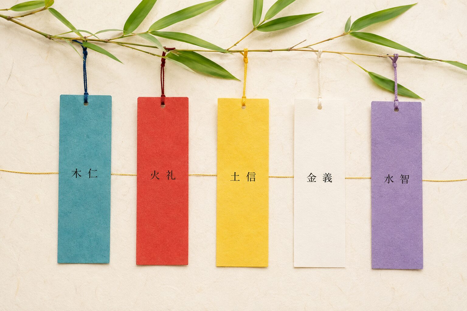 ivory washi 背景に painterly な 5 枚の短冊が横並びで配置、左から順に青の短冊+「木 仁」、赤の短冊+「火 礼」、黄の短冊+「土 信」、白の短冊+「金 義」、紫の短冊+「水 智」、それぞれの短冊の上部に細い紐が結ばれて笹枝の一部から下がっている、5 枚を細い金線でゆるやかに結ぶ。短冊の五色と陰陽五行説の対応を視覚化