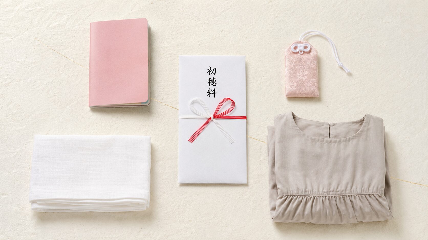 ivory washi 背景に painterly な俯瞰画像。中央に紅白蝶結びの初穂料のし袋、左上に母子手帳、右上に安産お守り袋、下に折りたたまれた腹帯とウエストゴムのワンピース。安産祈願の持ち物と服装を象徴