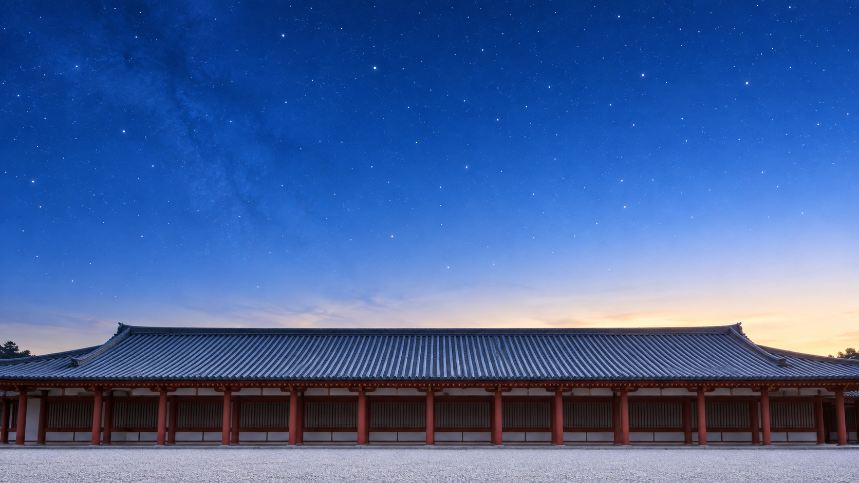 夜明け前の澄んだ空に小さな星が散らばり、画面の下には宮殿風の大きな建物の瓦屋根と朱塗りの柱がのぞく風景のイメージ画像。空は上が深い青で、地平線に近いほど淡い朝の色に変わっていく。星や空の異変を観測して吉凶を占った、朝廷の天文の役人としての安倍晴明の仕事を表した画像。